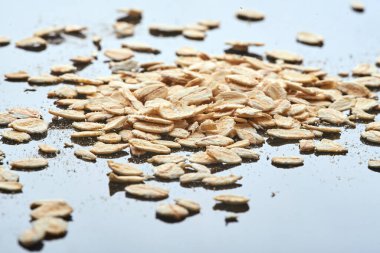 Yulaf ezmesi siyah bir yansıtıcı masanın üzerinde bir yığın halinde yatar. Bir sürü yulaf ezmesi. makro fotoğraf. arkaplan