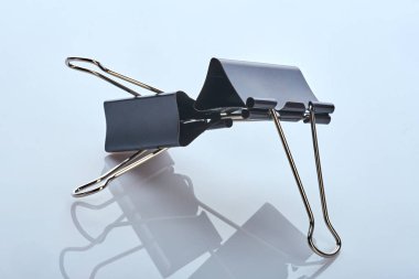 Beyaz yansıtıcı yüzeyde iki metal kırtasiye malzemesi duruyor. makro fotoğraf. yan görünüm