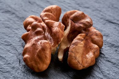 Çekirdek cevizi siyah kaba bir yüzeyde yatar. makro fotoğraf. Yakın plan. Soyulmuş fındık