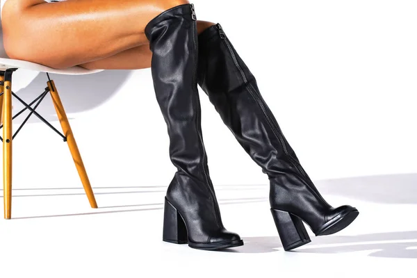 白い背景に影のあるモデルの足の上に黒い異端者のブーツ ジャックブーツ スタジオ撮影 細い足だ ファッショナブルなブーツ — ストック写真