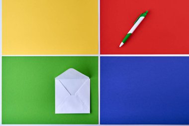 çok renkli kağıt arkaplan. Sarı, yeşil, kırmızı ve mavi. Kırmızı arka planda yeşil zarfın üzerinde bir kalem var. Beyaz çizgili renkli desen. Beyaz çizgiler görüntüyü böler. soyut arkaplan