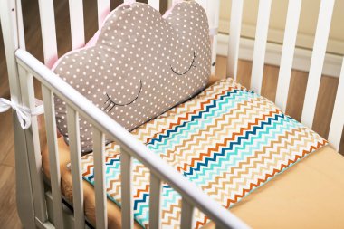 Kutulu pembe yastıklı boş bir bebek beşiği. Kahverengi yatak. Bebek için rahat bir yatak. konu fotoğrafı