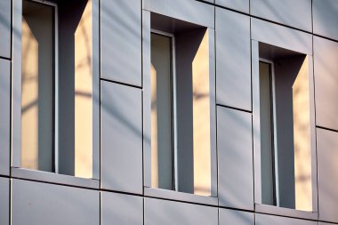 Şehir çevresindeki binada gölgeli üç pencere var. Sanat fotoğrafı. reddet