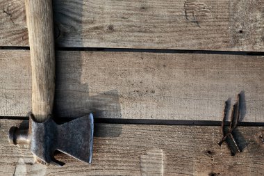 Köyün masasında eski bir çekiç ve yamuk çivi var. Pas. Çatlak, çizik ev yapımı bir masa. inşaat arkaplanı