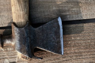 Eski paslı bir çekiç bir köyün masasında yatıyor. Çatlak, çizik ev yapımı bir masa. İnşaat geçmişi. Eski usul. güneş ışığı