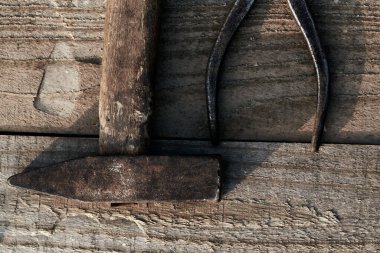 Bir ağacın tepesinde eski bir çekiç ve kerpeten duruyor. Pas. çatlamış, ev yapımı bir masa. inşaat arkaplanı