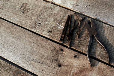 Kerpeten ve yamuk tırnaklar ağacın tepesinde duruyor. Pas. Çatlak, çizik ev yapımı bir masa. inşaat arkaplanı