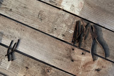 Kerpeten ve yamuk tırnaklar ağacın tepesinde duruyor. Pas. Çatlak, çizik ev yapımı bir masa. inşaat arkaplanı