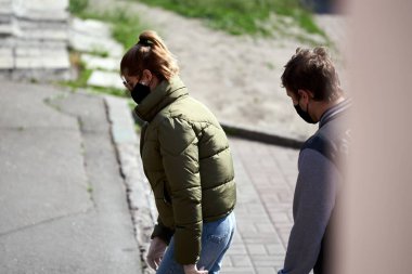 Tıbbi maskeli ve eldivenli insanlar sokakta yürürler. Bir şeyler düşün. Karantina mesafesinde. Sokak fotoğrafı. covid-19.