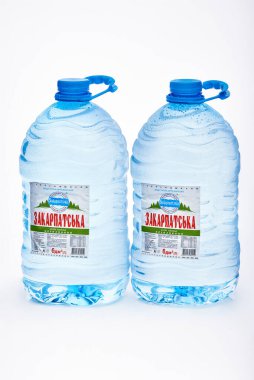 Kyiv, Ukrayna, 04.04.2020: iki büyük sulu Zakarpatska maden suyu şişesi ve beyaz arka planda yansıması olan damlalar. Stüdyo fotoğrafı makro