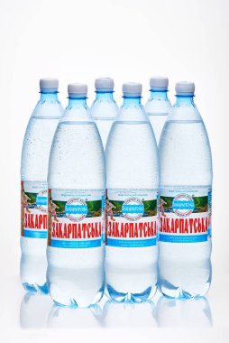 Kyiv, Ukrayna, 04.04.2020: altı sulu Zakarpatska maden suyu şişesi ve beyaz arka planda yansıması var. Stüdyo fotoğrafı makro