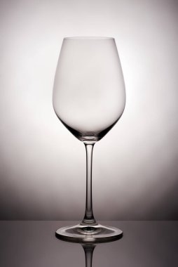 Kristal cam beyaz arka planda yansıtıcı yüzeyde duruyor. Stüdyo fotoğrafı Ürün. Şarap kadehinden güzel bir gölge. makro fotoğraf.