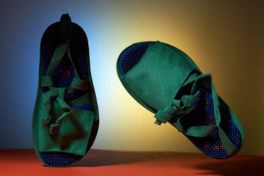 Arka planında metal iğneler olan yeşil masaj terlikleri. Rahatlama ve sağlık için. Promosyon ve konu fotoğrafçılığı