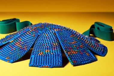 Sarı arka planda papatya şeklinde mavi bir masaj minderi var. Reklamcılık ve konu çekimi. Rahatlama ve sağlık için..