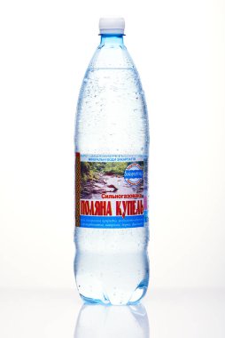 Kyiv, Ukrayna, 04.04.2020: sulu bir şişe Polyana Kupel maden suyu, beyaz arka planda yansıması olan damlalar. Stüdyo fotoğrafı makro.