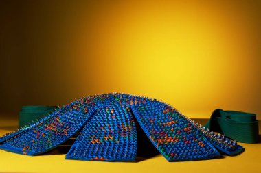 Sarı arka planda papatya şeklinde mavi bir masaj minderi var. Reklam, tematik ve konu çekimi. Rahatlama ve sağlık için.