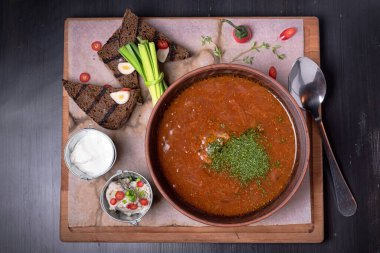 Ukrayna borsch 'u porselen tabak ve ekmek, soğan ve sos, köy zenginliği üzerine. Restoran hediyesi. Kafe menüsü için. ahşap masa.