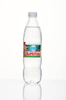 Kyiv, Ukrayna, 04.04.2020: sulu bir şişe Zakarpatska maden suyu ve beyaz arka planda yansıması olan damlalar. Stüdyo fotoğrafı makro.