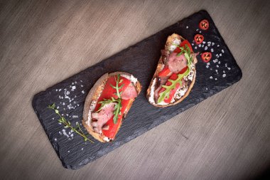 Taş tabaklar üzerinde iki vahşi et ve Bulgar biberi taslağı. Restoran hediyesi. Kafe menüsü için. Tahta masa. tuz, biber kırmızısı