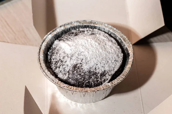 Alüminyum kutunun üstünde krema şekerli cheesecake. Pasta üstte.