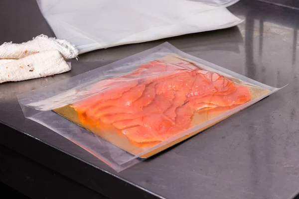 Fish production. Sliced pieces of fish lies in the package for further sealing