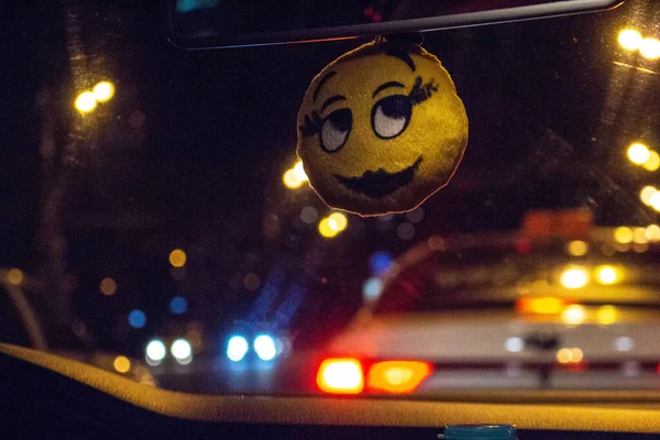 Soft toy - smiley meisje op de auto achteruitkijkspiegel. Sluiten — Stockfoto