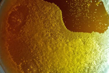 Arka planda bardak köpüklü bira köpüğü. Yaklaşırken