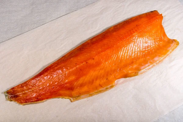 Smoked red fish from production lies on paper. Still life — Stock Photo, Image