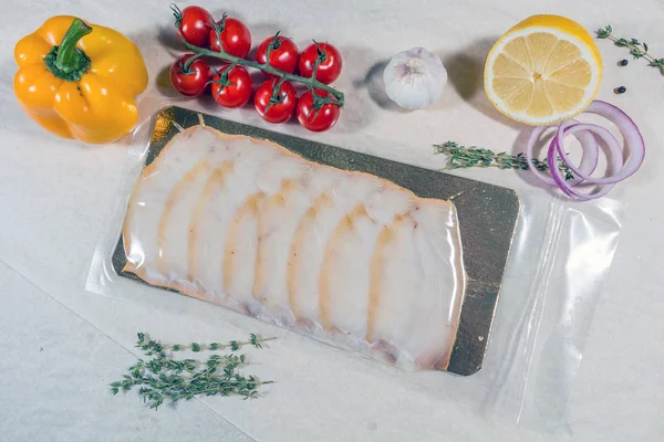密封された真空ビニール袋に白い魚。完成品生産から ロイヤリティフリーのストック画像