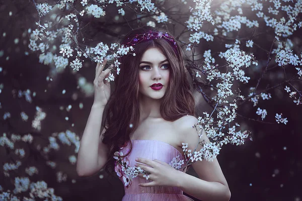 Hermosa chica romántica con el pelo largo en vestido rosa cerca del árbol de flores . — Foto de Stock