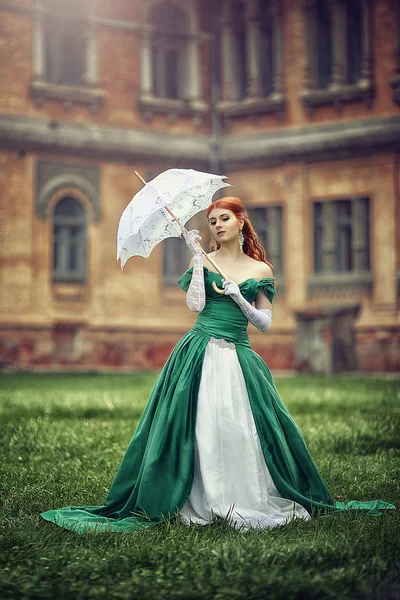 Beautiful young red-haired girl in a medieval green dress. — Stock Photo, Image
