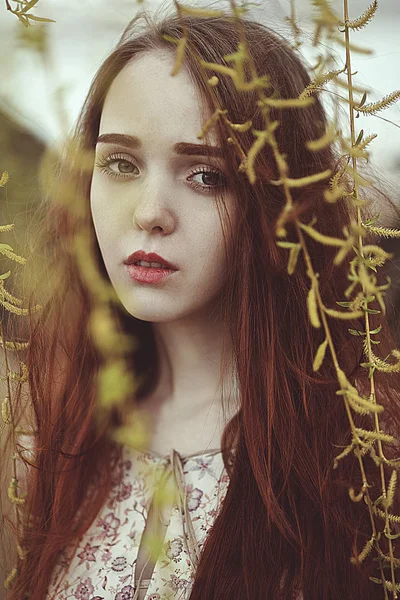 Portret van een romantische meisje met rode haren in de wind onder een wilg boom. — Stockfoto