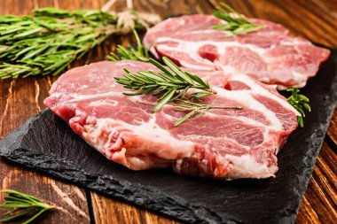 Çiğ domuz biftek çeşnilikler ahşap bir yüzeyi ile