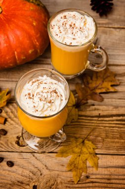 Kabak güler yüzlü, rustik ahşap zemin üzerine krem şanti ile spice latte. seçici odak