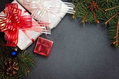 Noel dekorasyonu, köknar ağaç dalları ve hediyeler koyu arka plan üzerinde. Üstten Görünüm