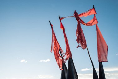 Mavi gökyüzü altında kırmızı ve siyah vintage bayrakları