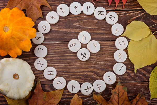 Wooden runes on autumn background. Esoteric tools.