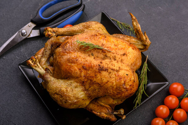 Baked whole chicken on dark background, celebration of  Christmas, thanksgiving. 