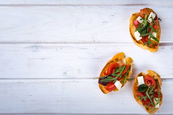 Bruschetta Met Tomaten Mozzarella Kaas Kruiden Een Witte Achtergrond Bovenaanzicht — Stockfoto