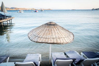 Gün batımında kumsalda güneşlik ve şemsiyeler, Ege denizi, Türkiye