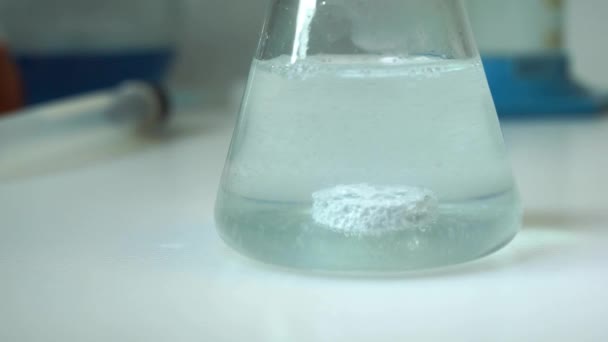Shot Of Effervescent Pill Dissolving In A Test Tube Of Water. Close up. — 图库视频影像