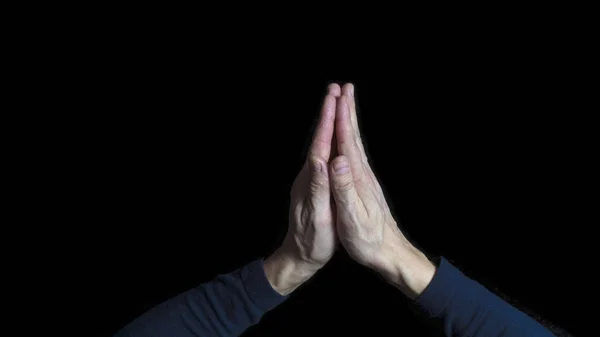 Man hands praying in dark background. Close up.