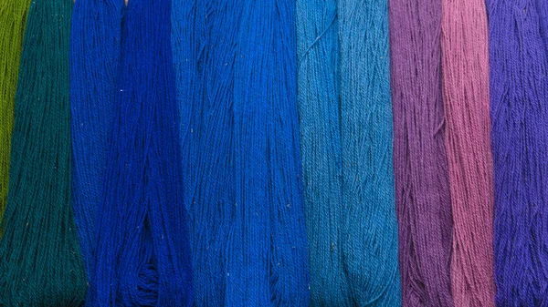 Wall of many colors of raw yarn for sale. Background texture. Stock Image