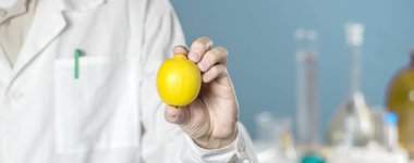 Beyaz üniformalı, limonlu bir erkek doktor. Laboratuvar geçmişi. Sağlığınız için vitaminler.