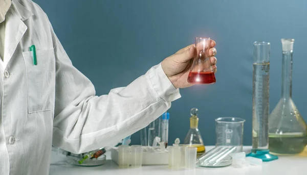 Cientista do sexo masculino segurando em copos de laboratório frasco mão em fundo de laboratório químico, pesquisa de laboratório de ciência e conceito de desenvolvimento — Fotografia de Stock