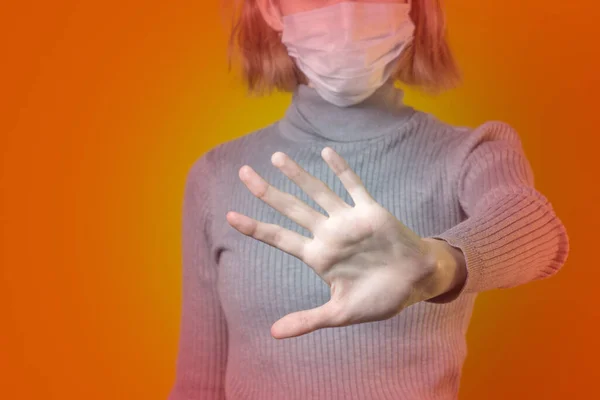 Detener el virus y las enfermedades epidémicas. Mujer sana con máscara protectora médica azul que muestra un gesto de parada. Protección de la salud y prevención durante la gripe y los brotes infecciosos — Foto de Stock