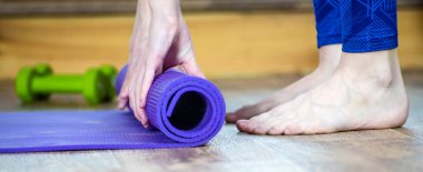 Meditasyon seansı, fitness sağlıklı düşünceli yaşam tarzı konsepti. Formda bir kadının elleri yuvarlanan spor salonu, pilates yoga minderi, yoga stüdyosunda çalışmadan önce ya da sonra ya da evde, yerde. Görüntüyü kapat