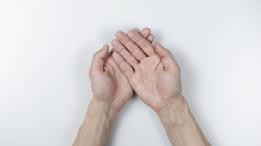 Fotoğrafçı, iki eli avuçlarında beyaz bir arka planda..