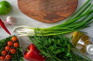 Bıçak ve ahşap kesme tahtasının yüksek açılı natürmort manzarası Taze otlar ve çeşitlilikle çevrili