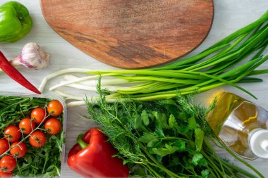 Bıçak ve ahşap kesme tahtasının yüksek açılı natürmort manzarası Taze otlar ve çeşitlilikle çevrili